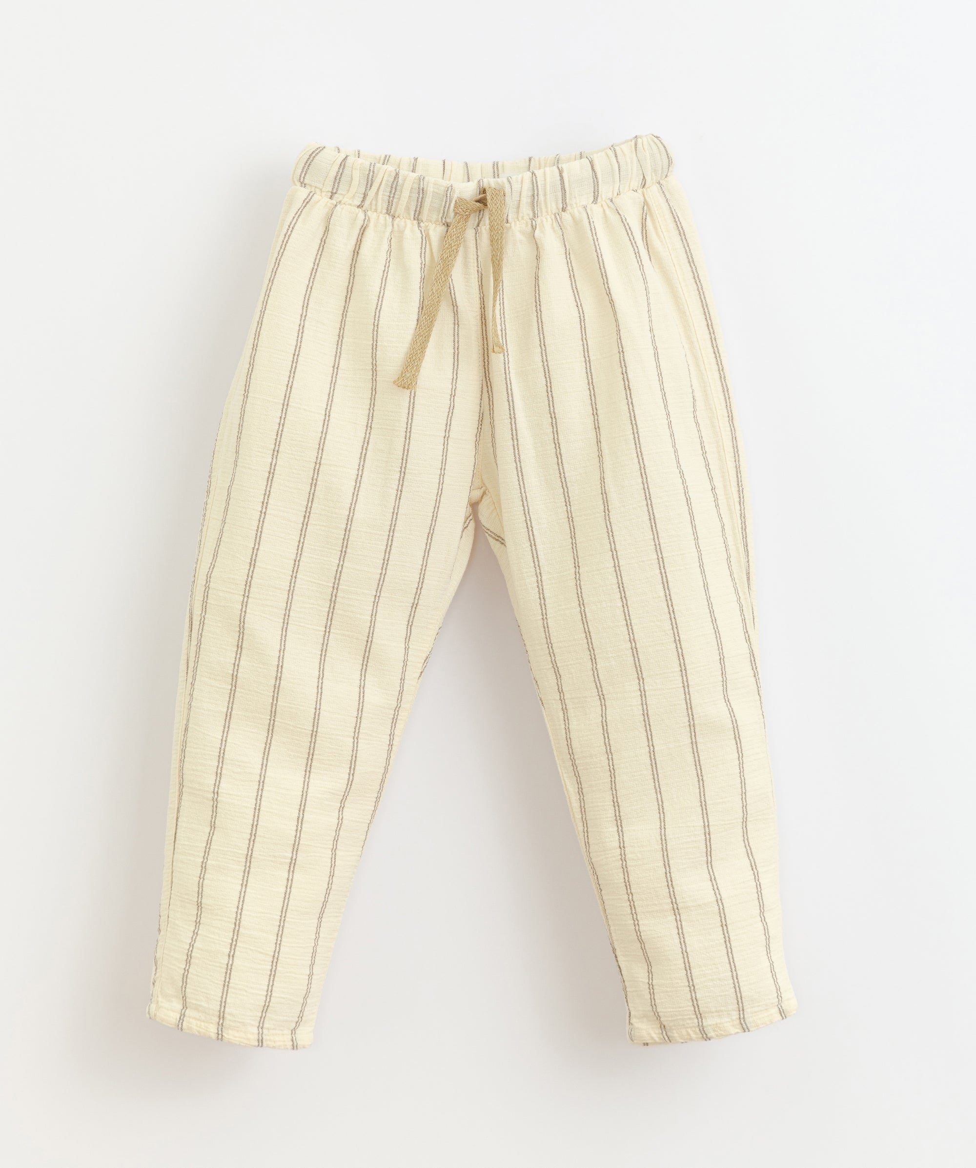 Baige trousers made of a mixture of woven and organic cotton. It has an elastic waist with an adjustable linen cord and one rear pocket. Made by Play Up.