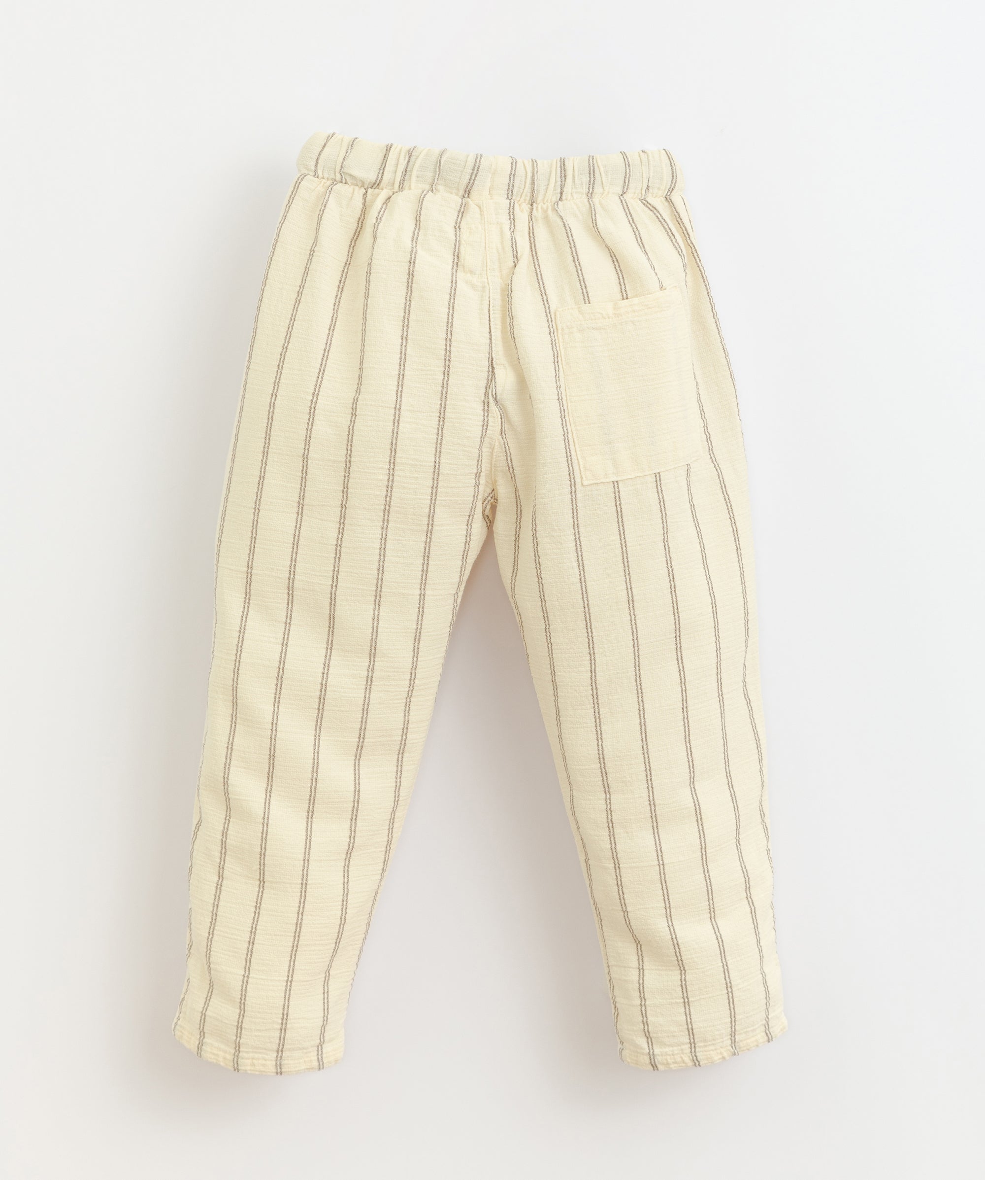 Baige trousers made of a mixture of woven and organic cotton. It has an elastic waist with an adjustable linen cord and one rear pocket. Made by Play Up.