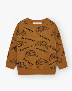 Brown jumper with all-over prints of croissants. Comes with ribbed cuffs and brushed cotton from the inside for extra warmth. Brand name is Nadadelazos