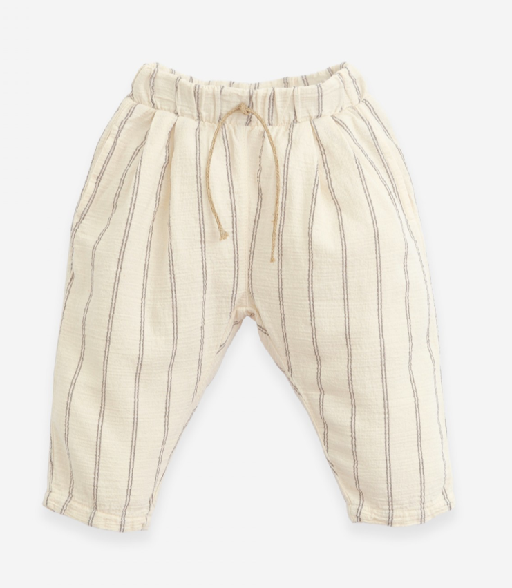 Baige trousers made of a mixture of woven and organic cotton. It has an elastic waist with a decorative jute cord and two side pockets. Made by Play Up.