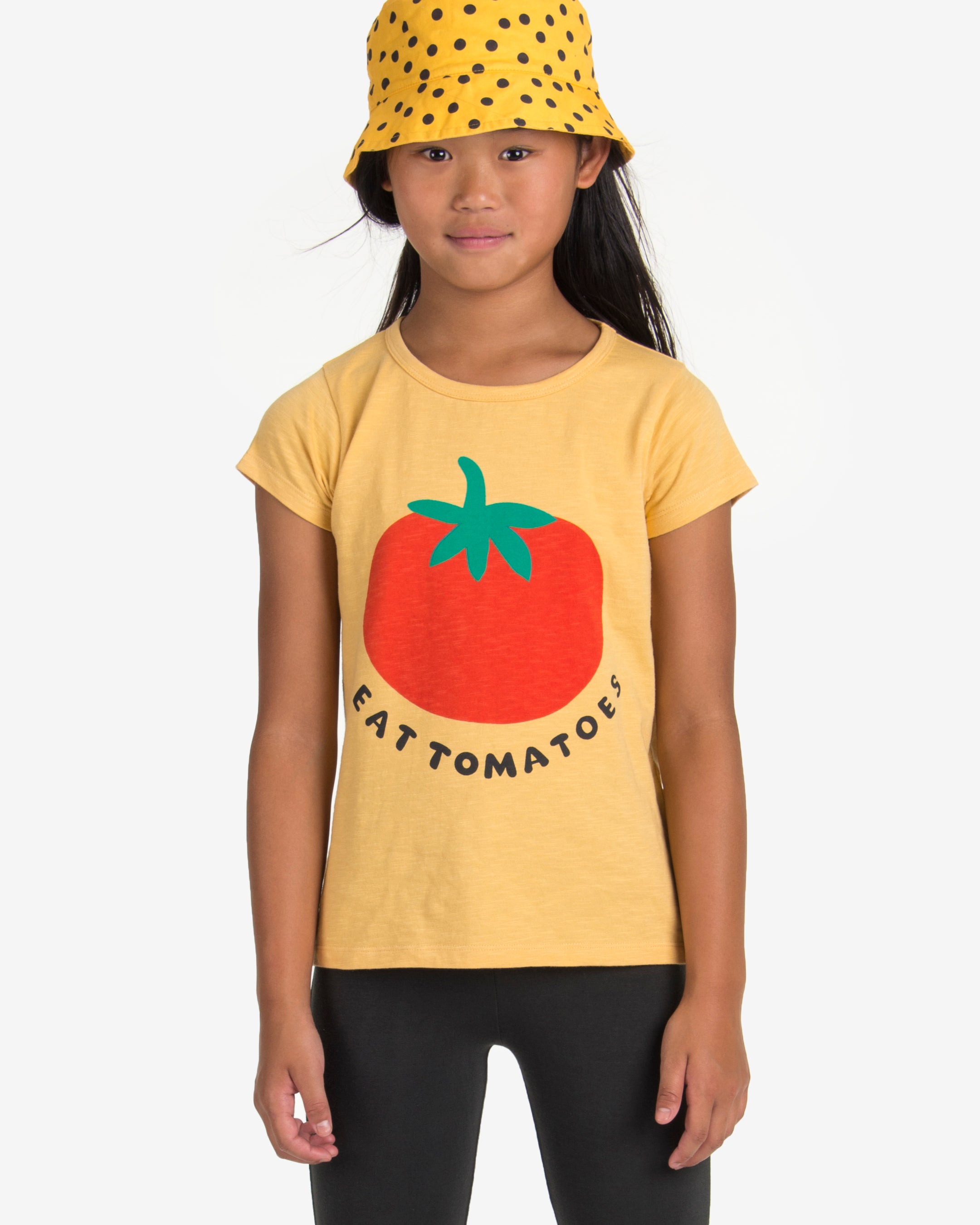 Yellow t-shirt with a big tomato print at the front. The phrase "EAT TOMATOES" is written in capital letters under the tomato print. Made by Nadadelazos