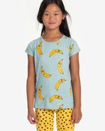 Load image into Gallery viewer, Model is wearing Turquoise T-shirt with a yellow bananas all-over print. Comes with a folded cuffs. Made by Nadadelazos
