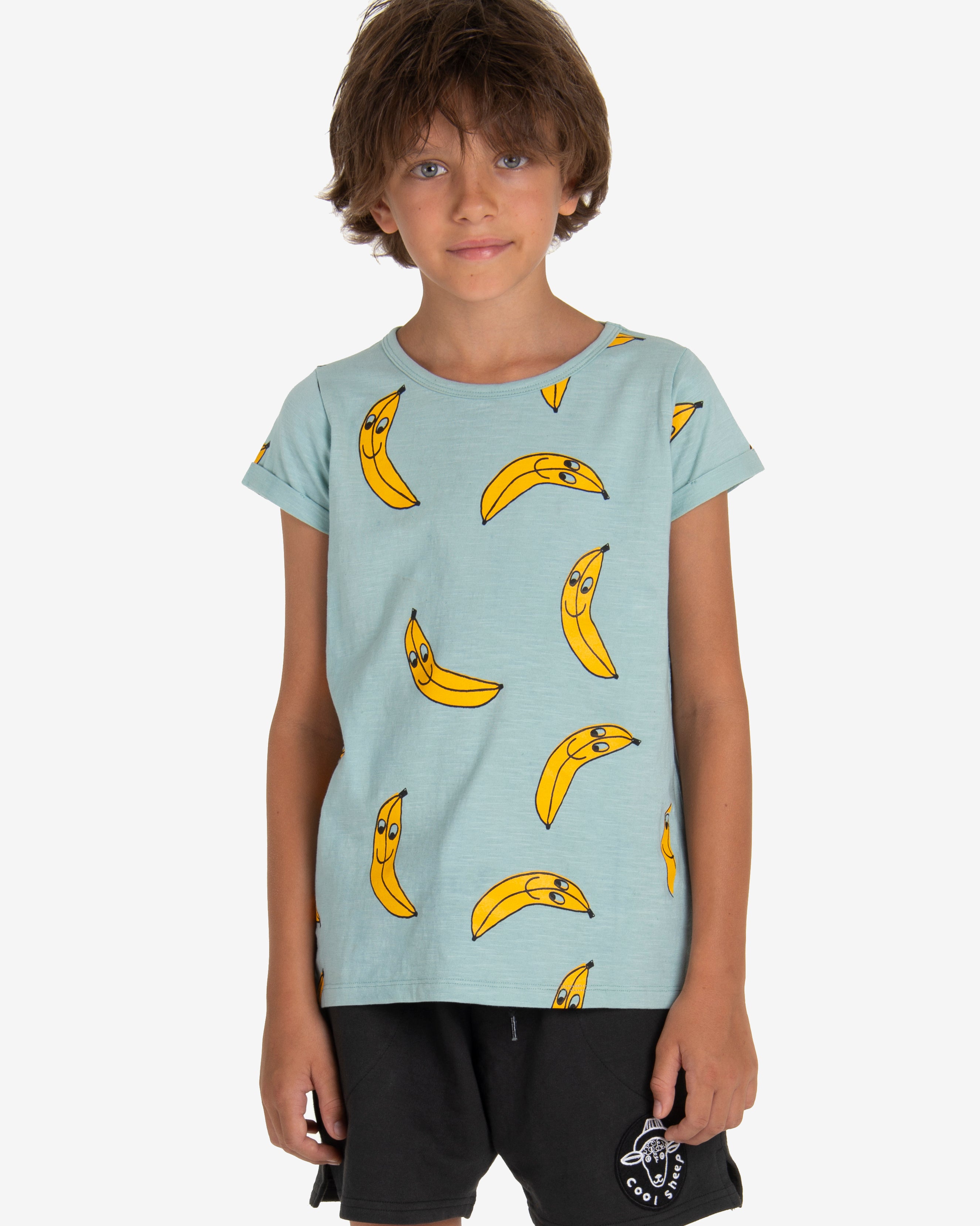 Model is  wearing Turquoise T-shirt with a yellow bananas all-over print. Comes with a folded cuffs. Made by Nadadelazos