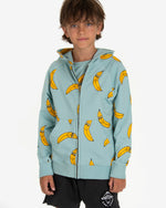 Load image into Gallery viewer, Model wearing Turquoise hoodie with a yellow bananas all-over print. The hoodie has a bronze zipper opening on the front and ribbed cuffs. Made by Nadadelazos
