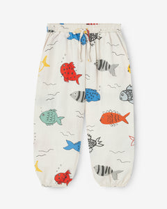 Off-white trousers with a big colourful fish print. The trousers have an elastic waistband with an adjustable cord. It also has two side pockets. Made by Nadadelazos
