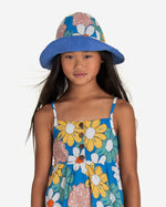 Load image into Gallery viewer, Model wearing Blue sun hat with big colourful flowers all-over print with matching dress.  Made by Nadadelazos

