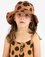 Load image into Gallery viewer, Model wearing Brown hat with a large black polka dots all-over print. Made by Nadadelazos
